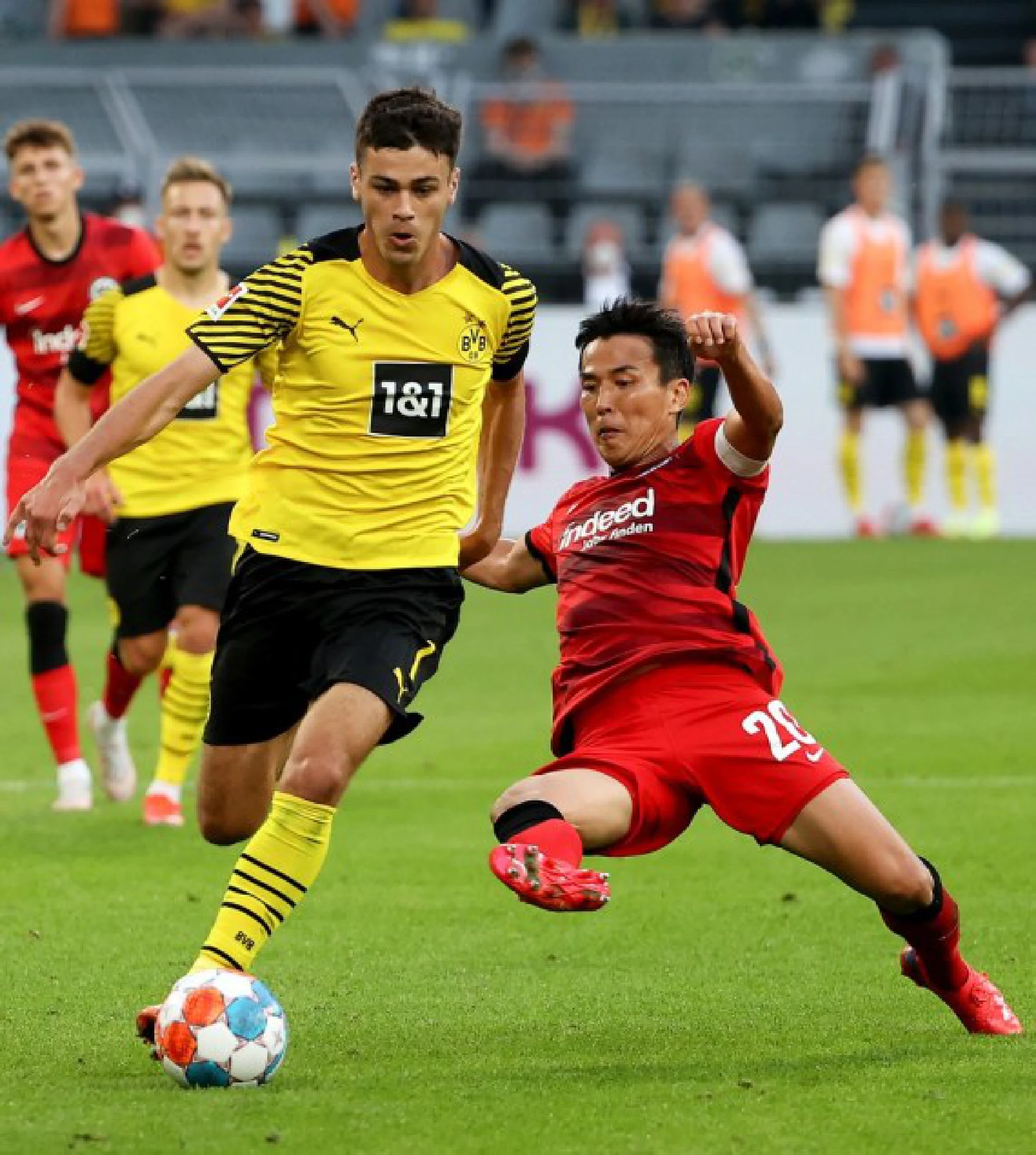 Giovanni Reyna (L) of Dortmund vies with Hasebe Makoto of Frankfurt during a German Bundesliga match in Dortmund, Germany, Aug. 14, 2021.