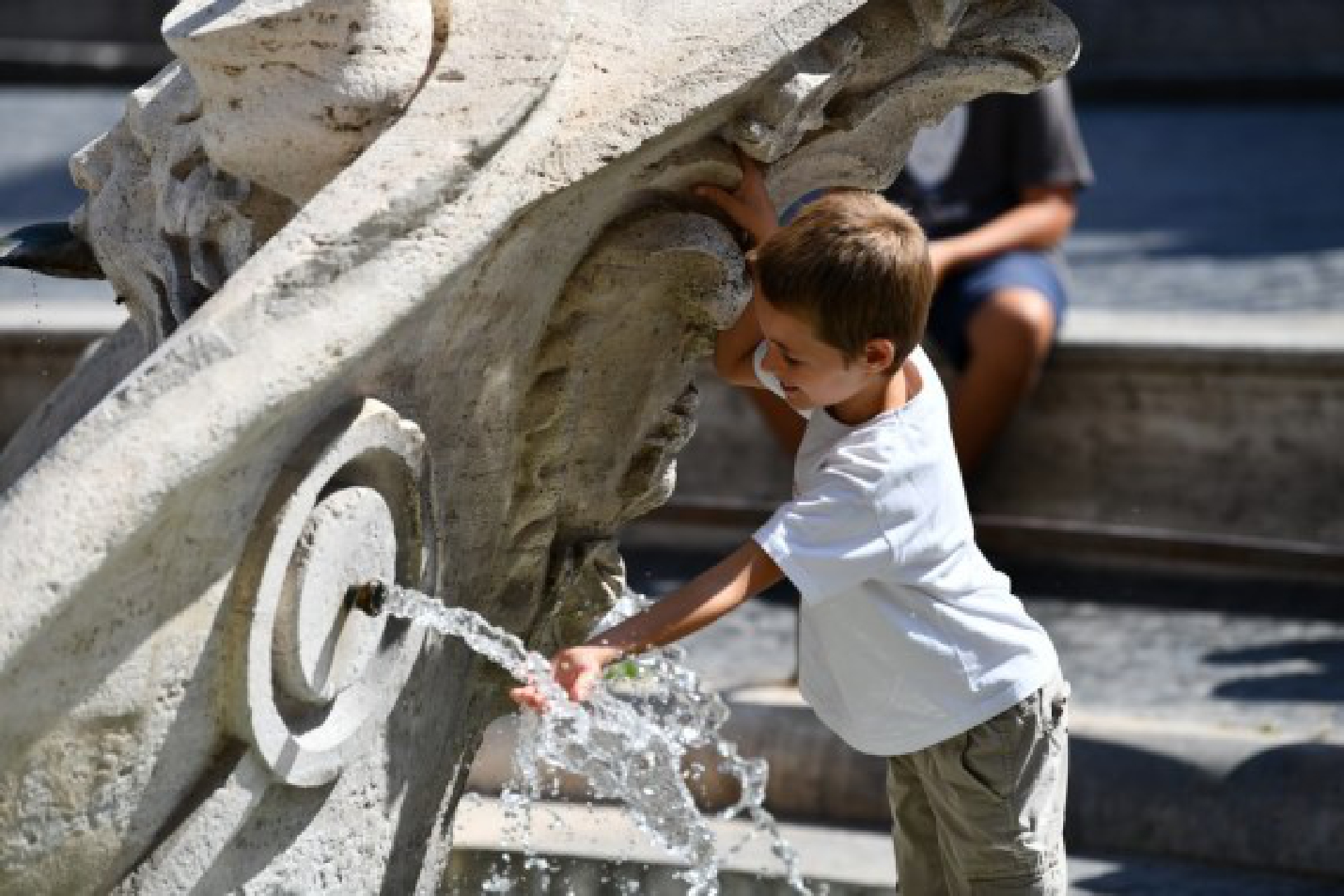  A boy refreshes himself with the water of the Barcaccia Fountain in the Piazza di Spagna in Rome, Italy, Aug. 12, 2021. 