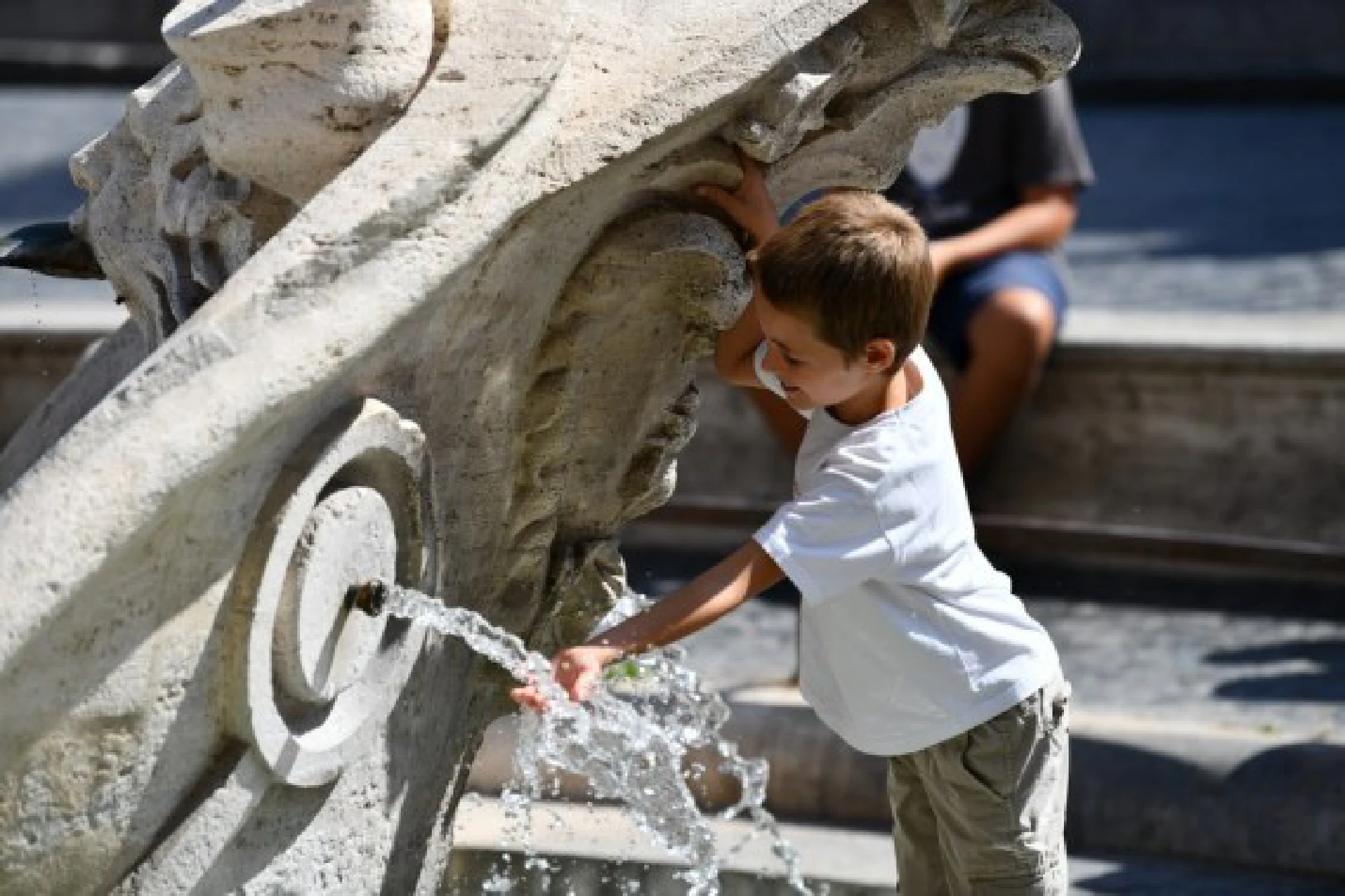  A boy refreshes himself with the water of the Barcaccia Fountain in the Piazza di Spagna in Rome, Italy, Aug. 12, 2021. 