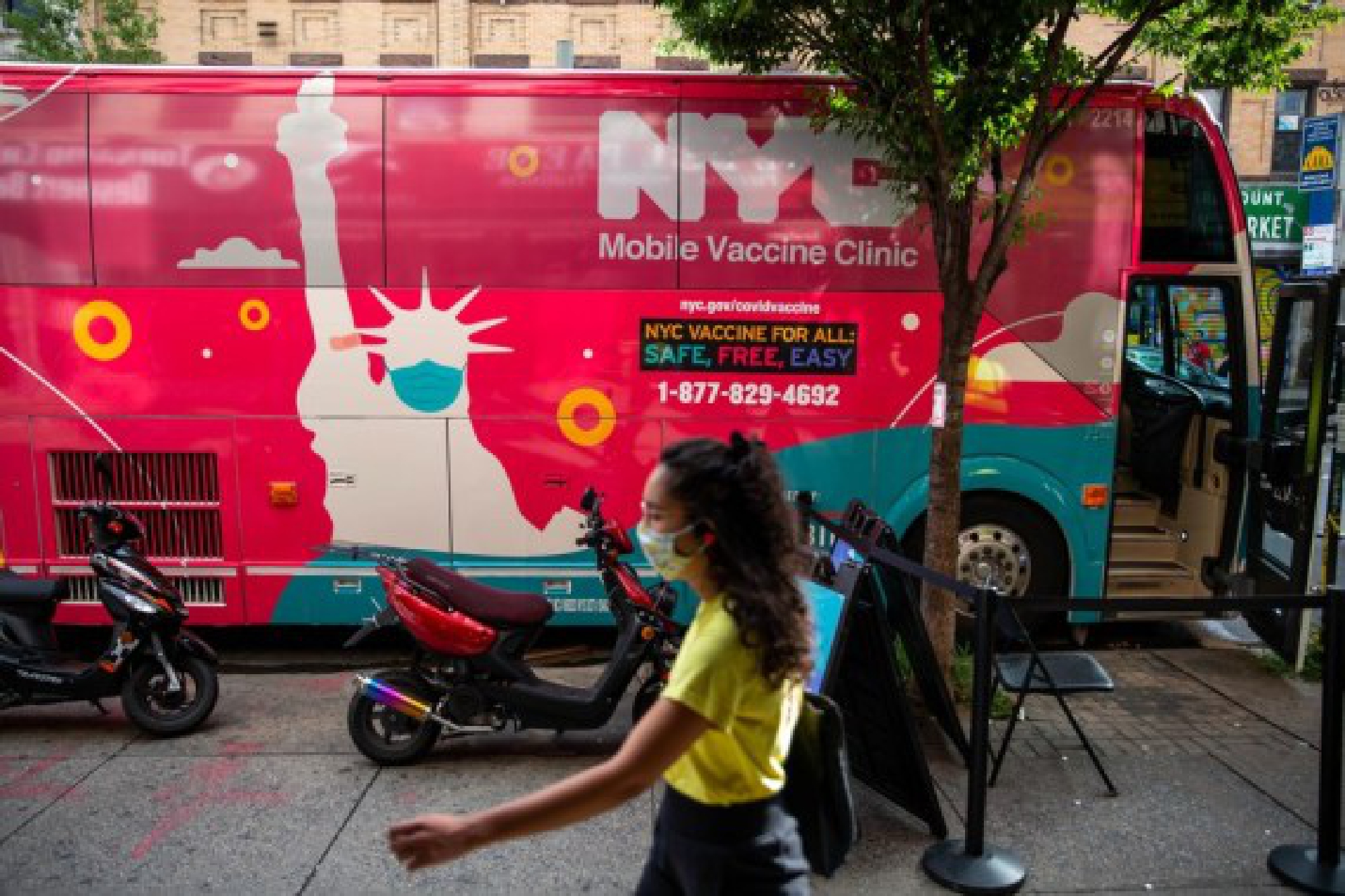 A pedestrian passes a mobile vaccine clinic in the Brooklyn borough of New York, United States, on Aug. 23, 2021. (Photo by Michael Nagle/Xinhua)