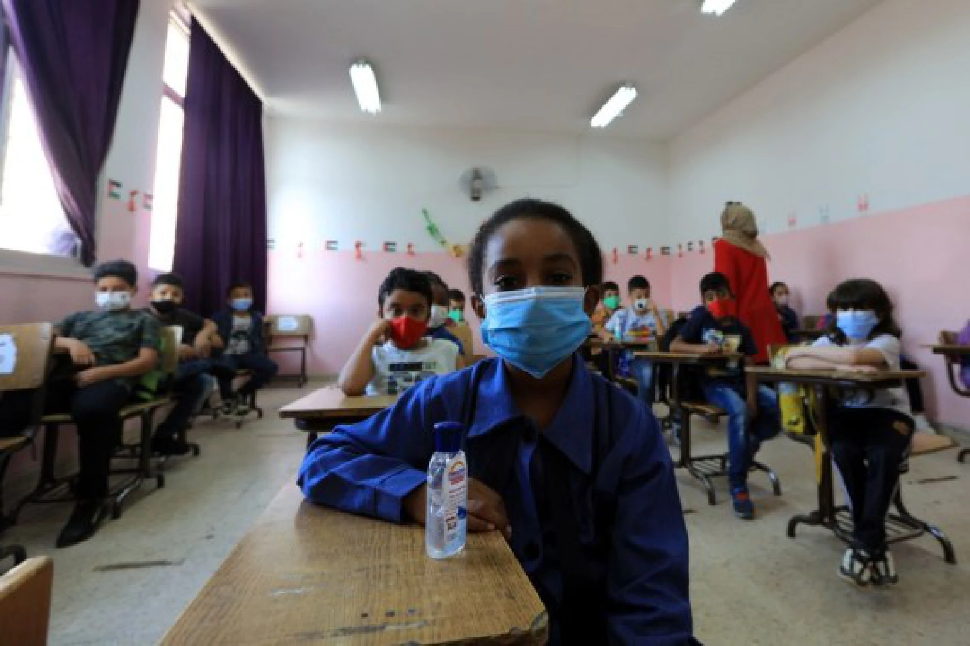 Students wearing face masks attend a class on the first day of the new school year at a public school in Amman, Jordan, Sept. 1, 2021.