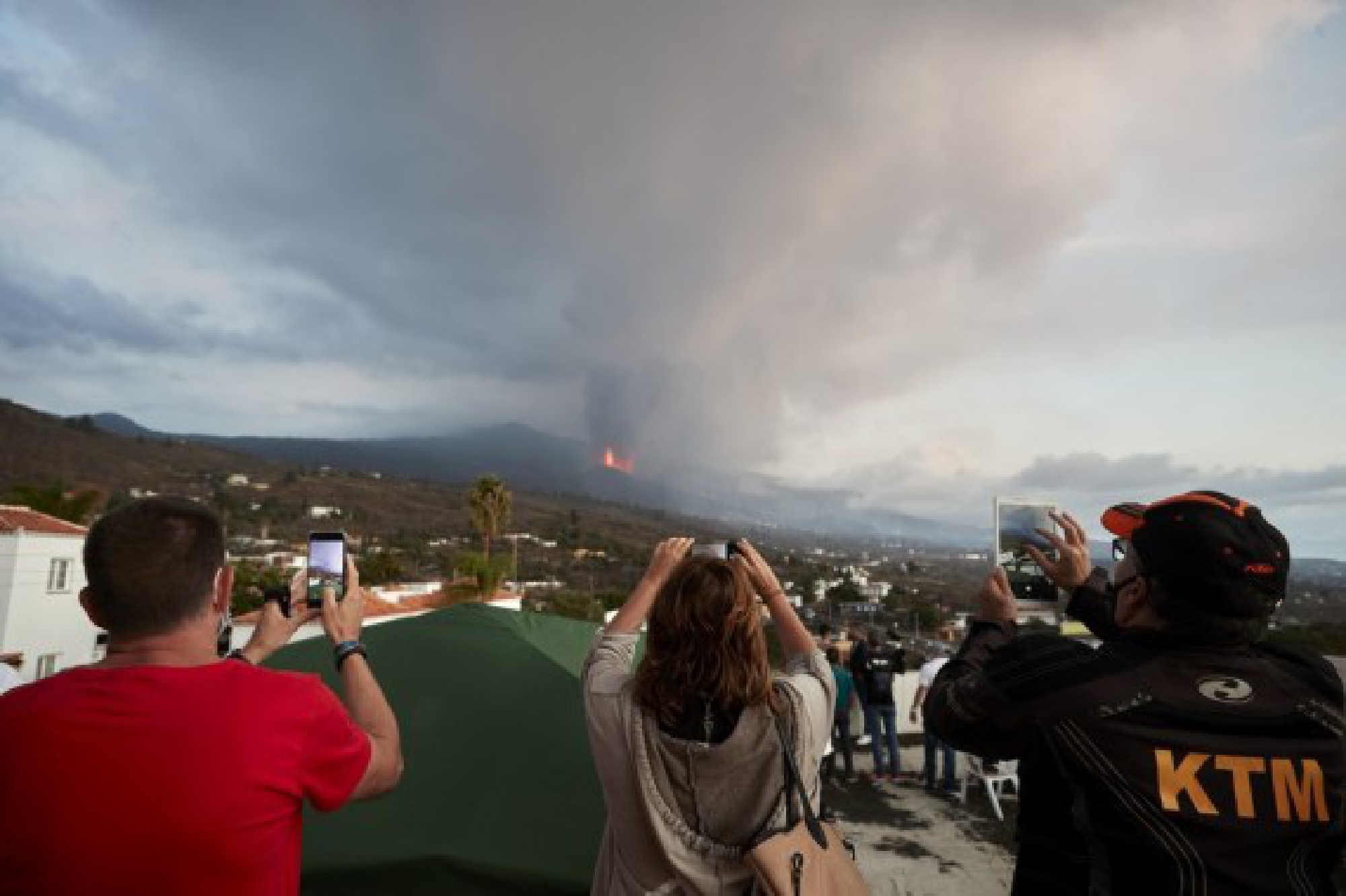 People watch the scene of volcanic eruption of Cumbre Vieja volcano in La Palma, Spain, Sept. 23, 2021.(Xinhua/Meng Dingbo)