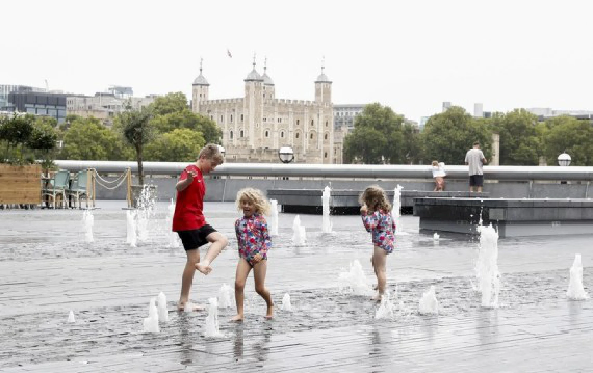 Children play with water in a fountain near Tower of London in London, Britain, on Aug. 13, 2021. 