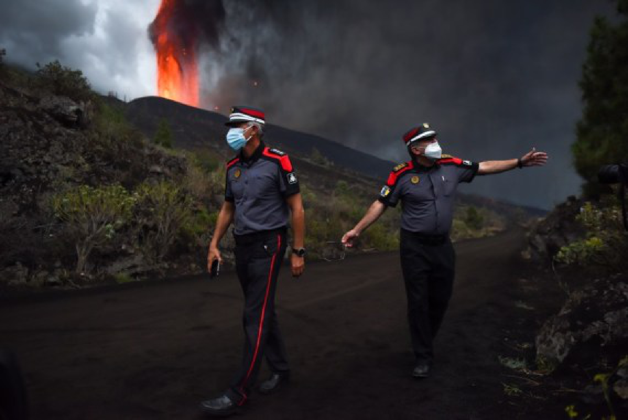 Police officers stop people from approaching the Cumbre Vieja volcano in La Palma, Spain, on Sept. 22, 2021.(Photo by Gustavo Valiente/Xinhua)
