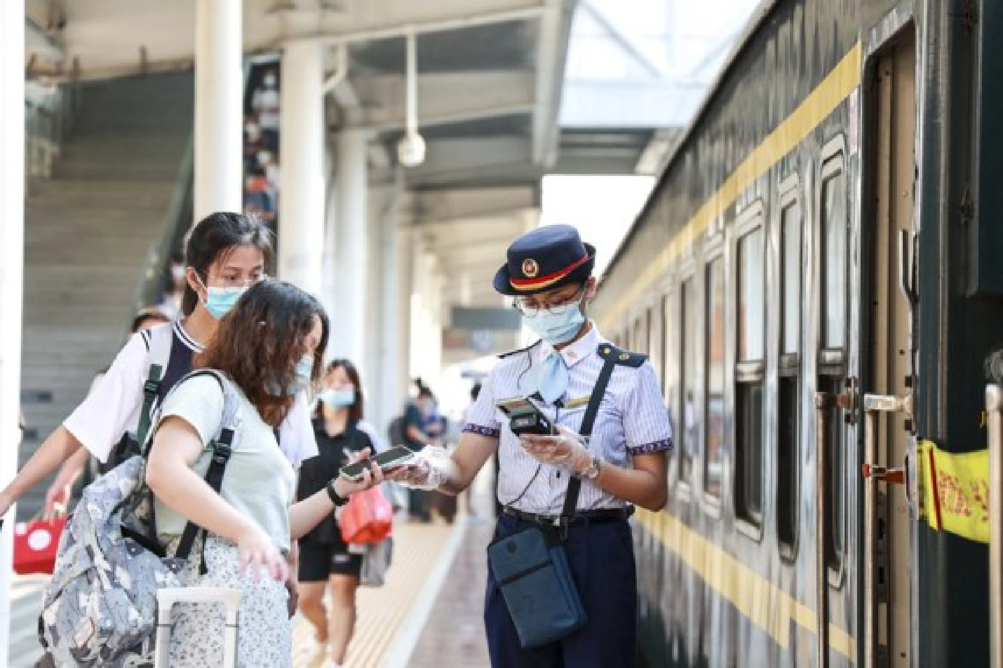 A staff member checks passengers' tickets at the Nanning Railway Station in Nanning, south China's Guangxi Zhuang Autonomous Region, Oct. 1, 2021. (Photo by Zhao Shilin/Xinhua)