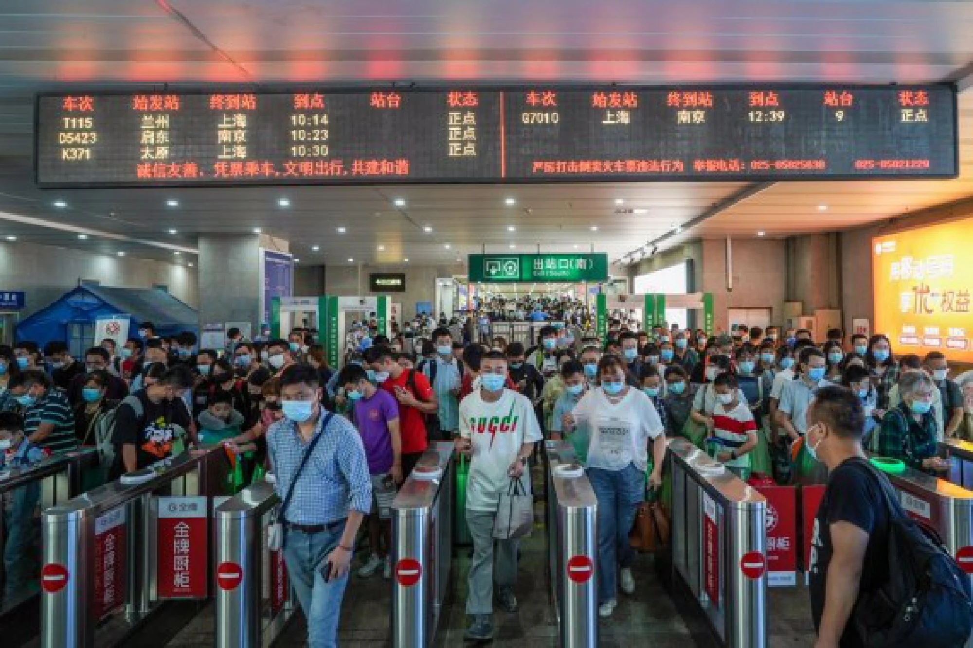 Passengers go through ticket-checking machines at the Nanjing Railway Station in Nanjing, east China's Jiangsu Province, Oct. 1, 2021. (Xinhua/Li Bo)