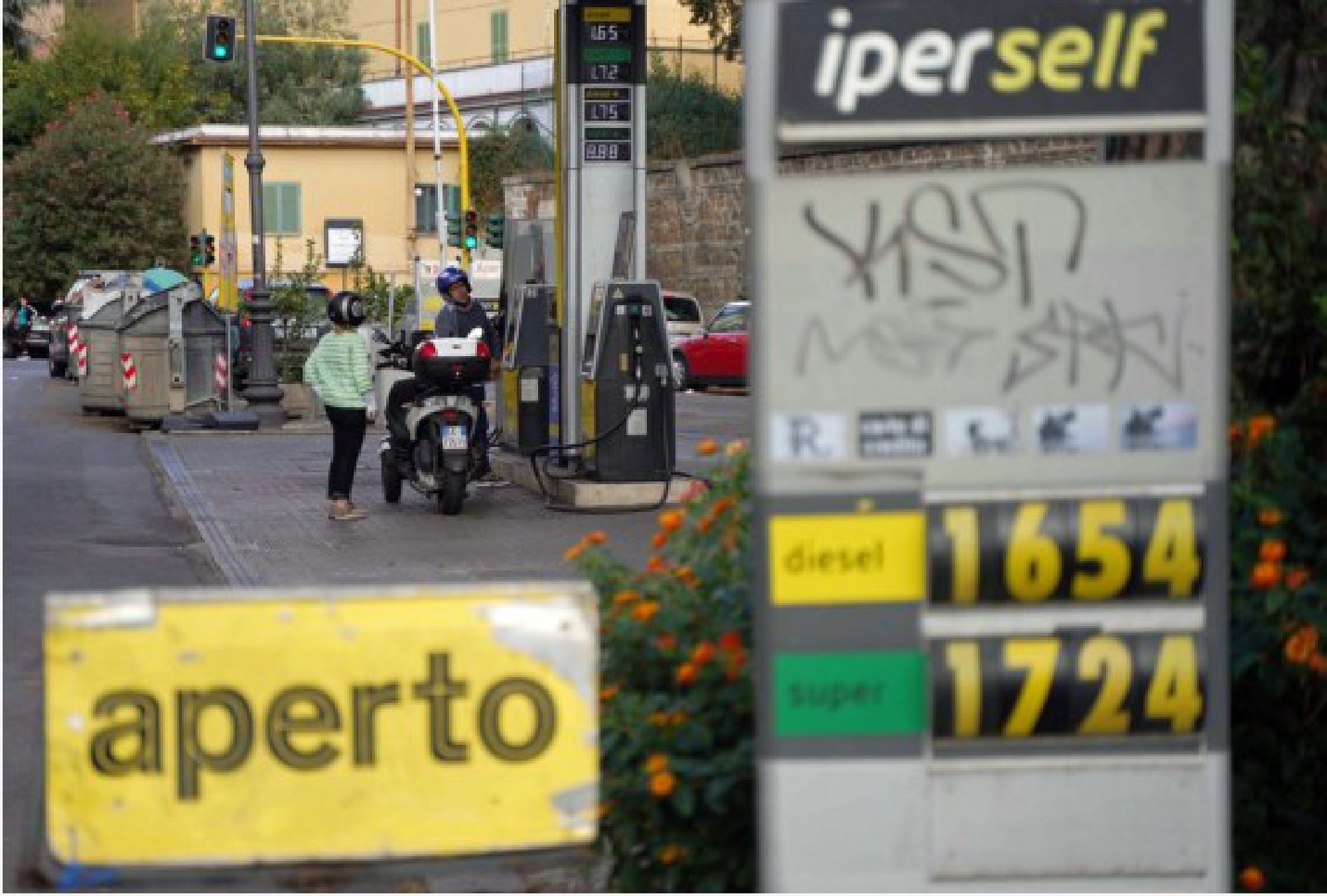 Customers fuel a motorcycle at a gas station in Rome, Italy, on Oct. 9, 2021.(Xinhua/Jin Mamengni)