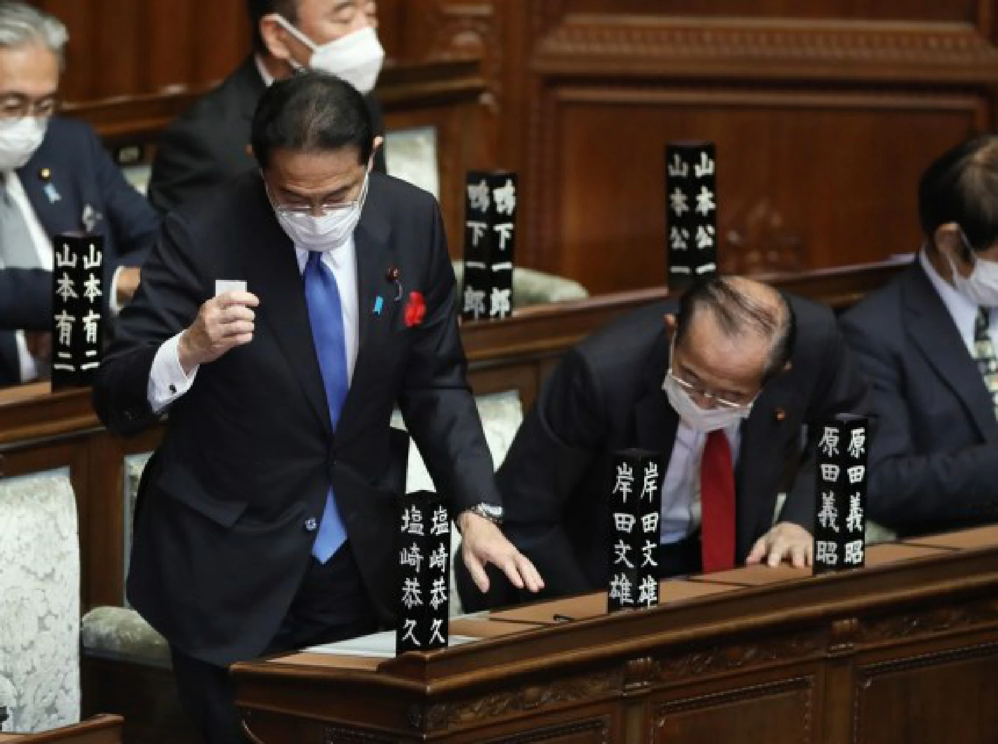 Fumio Kishida (L), leader of Japan's ruling Liberal Democratic Party (LDP), stands to cast his vote during a special Diet session in Tokyo, Japan, Oct. 4, 2021.(Xinhua/Du Xiaoyi)