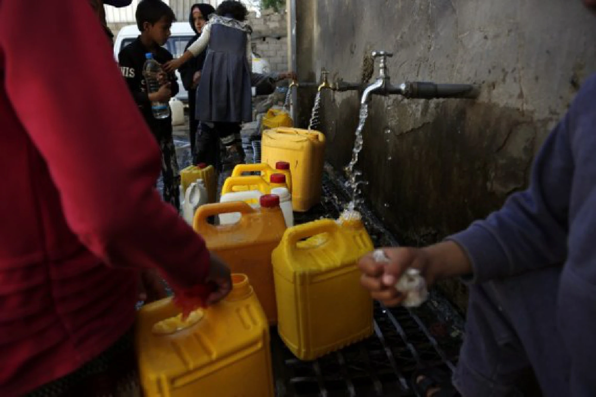 Yemeni children fill plastic barrels with water near a charity water tap in Sanaa, Yemen on Oct. 28, 2021. (Photo by Mohammed Mohammed/Xinhua)