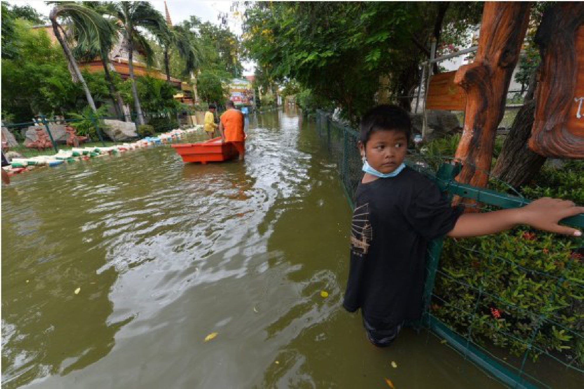 A boy stands on a flooded road on the outskirts of Bangkok, Thailand, on Sept. 3, 2021. (Xinhua/Rachen Sageamsak)