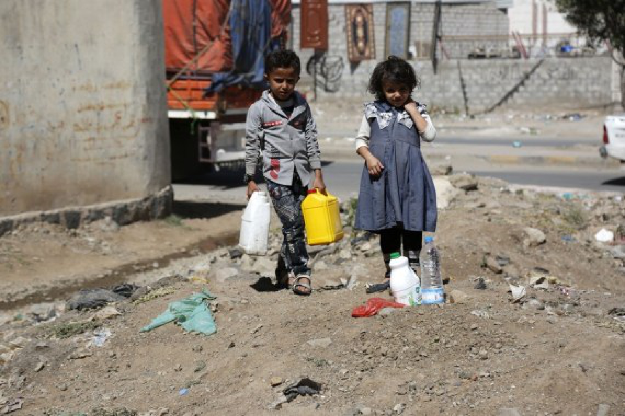 Children carry plastic water barrels to a charity water tap in Sanaa, Yemen on Oct. 28, 2021. (Photo by Mohammed Mohammed/Xinhua)
