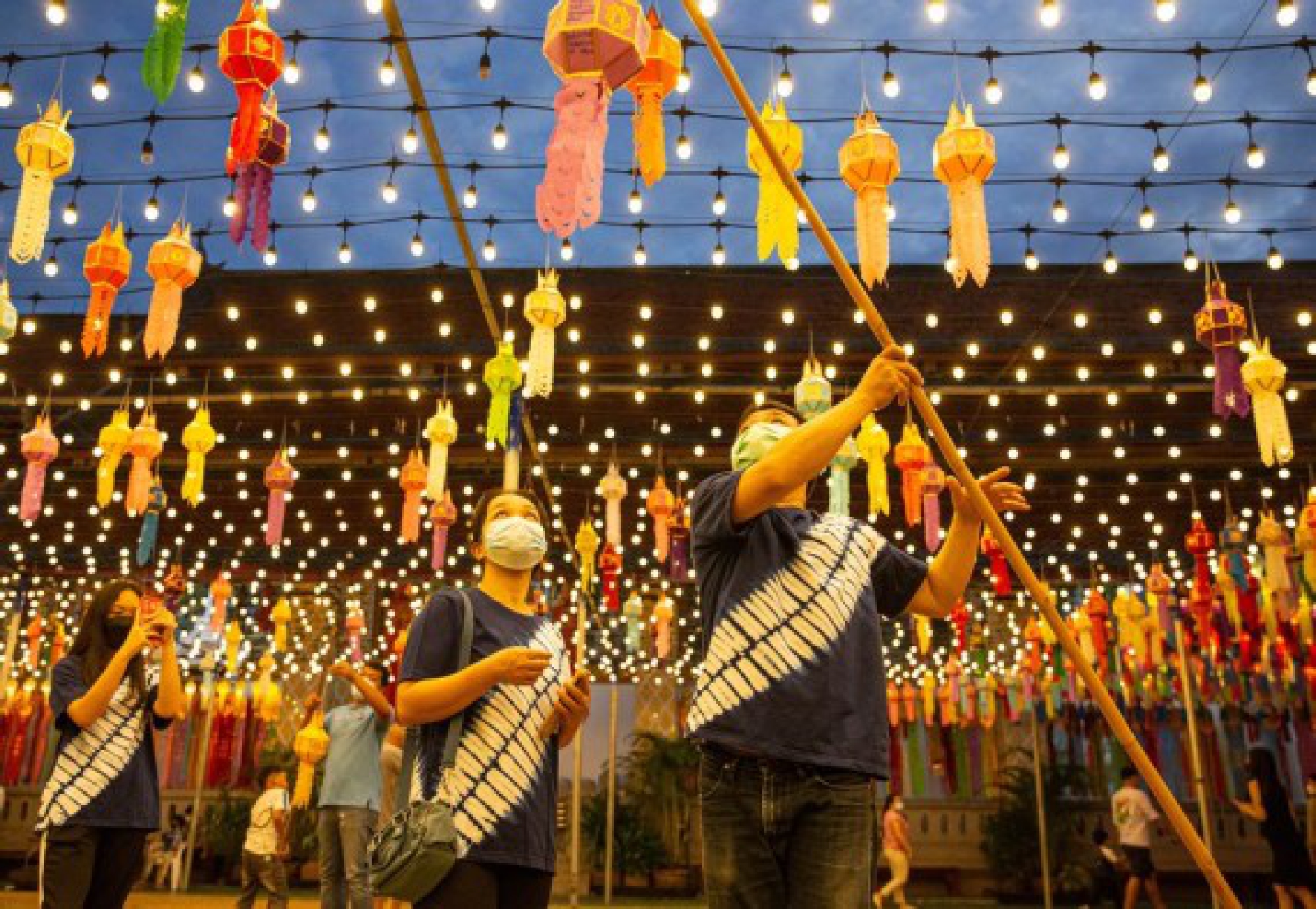A tourist hangs a lantern at the Wat Phra That Hariphunchai in Lamphun, Thailand, Oct. 25, 2021. (Xinhua/Wang Teng)