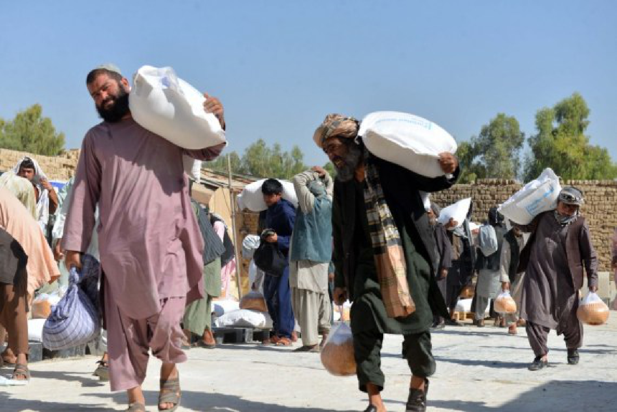 People carry relief assistance donated by World Food Programme (WFP) in Kandahar city, Afghanistan, Oct. 7, 2021. (Photo by Sanaullah Seiam/Xinhua)