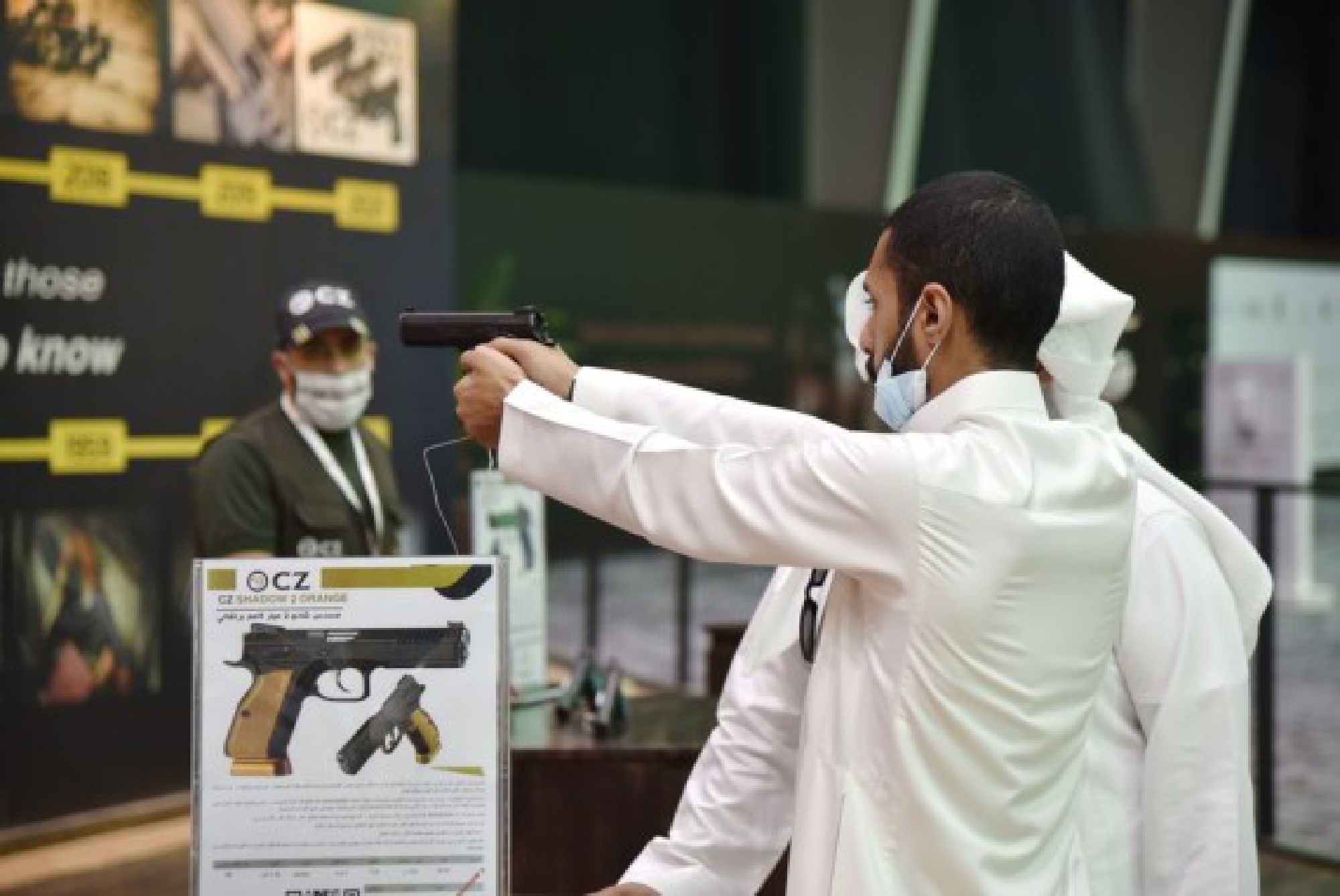 Photo taken on Oct. 5, 2021 shows a visitor handled a pistol for trying at the hunting exhibition, in the headquarters of the Saudi Falcon Club in Mulham, north of Riyadh, Saudi Arabia. (Xinhua/Wang Haizhou)