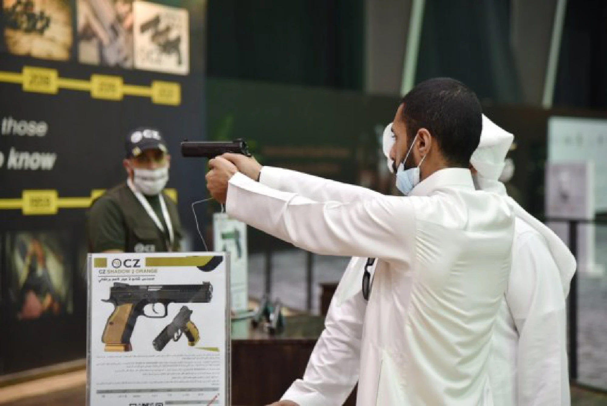 Photo taken on Oct. 5, 2021 shows a visitor handled a pistol for trying at the hunting exhibition, in the headquarters of the Saudi Falcon Club in Mulham, north of Riyadh, Saudi Arabia. (Xinhua/Wang Haizhou)