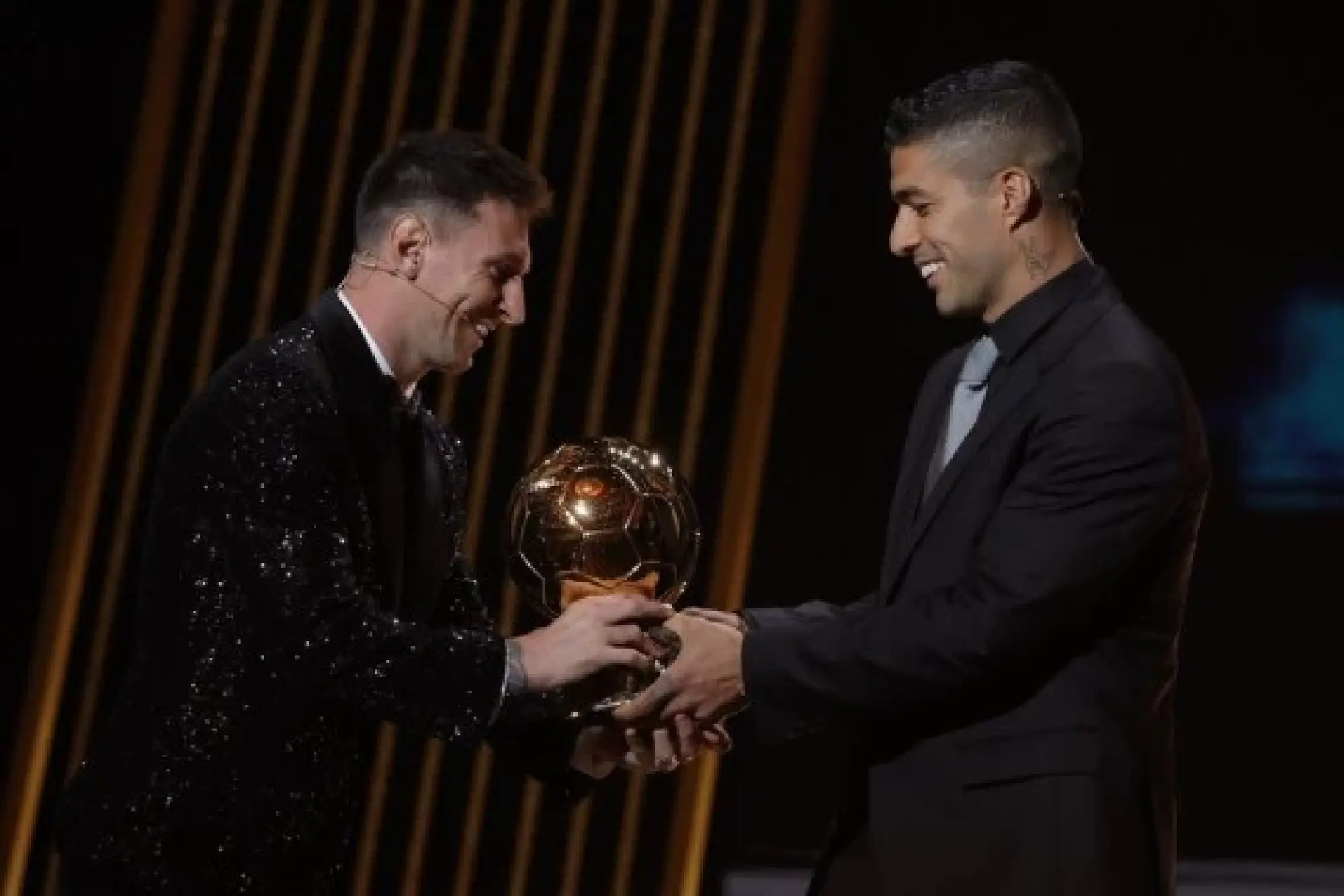 Lionel Messi (L) receives the trophy of the Men 2021 Ballon d'Or from his friend and former Barcelona teammate Luis Suarez. (Photo by Henri Szwarc/Xinhua)