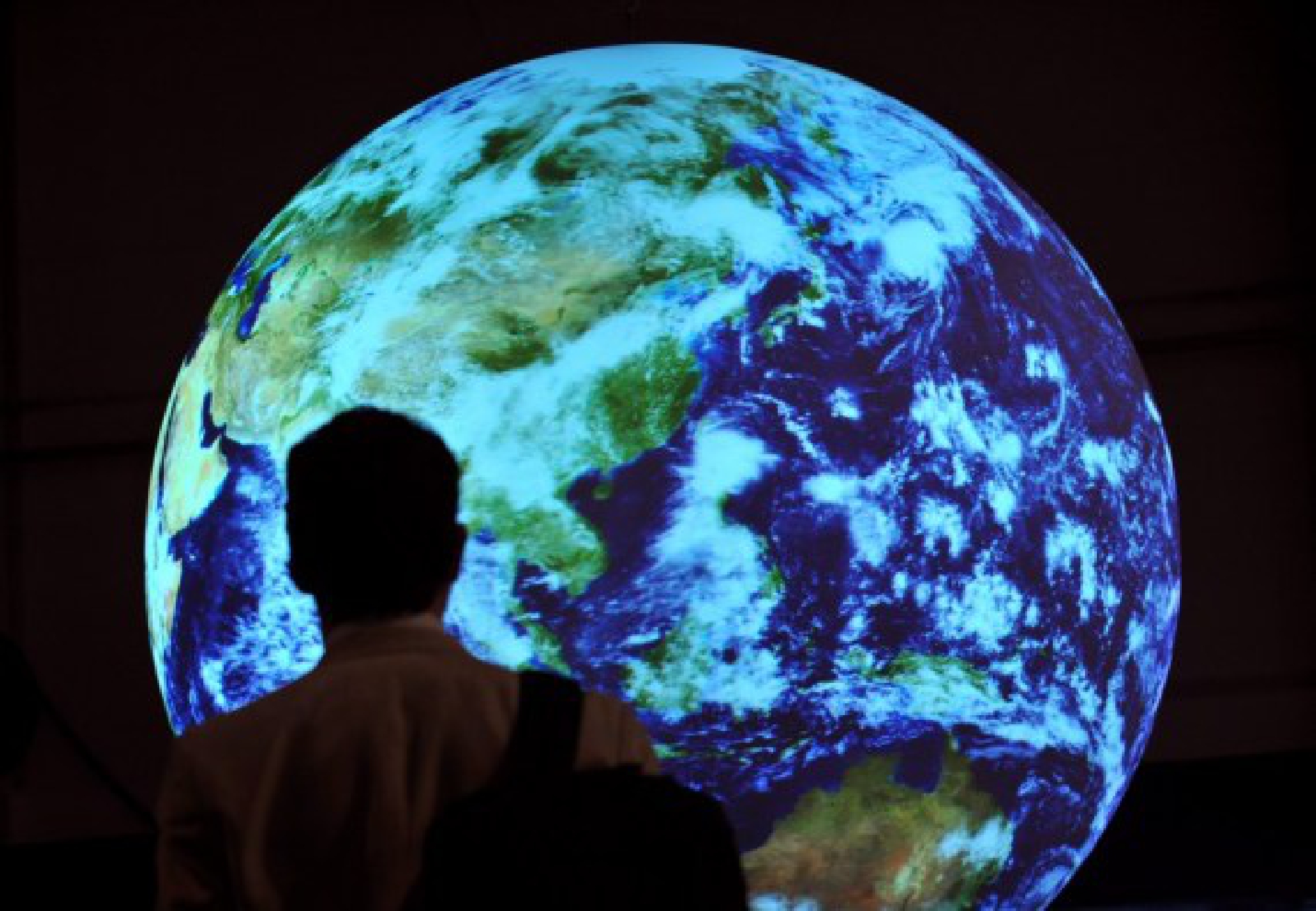  A man walks past an Earth model at the conference hall of the United Nations Climate Change Conference in Copenhagen, capital of Denmark, Dec. 17, 2009. (Xinhua/Wu Wei)