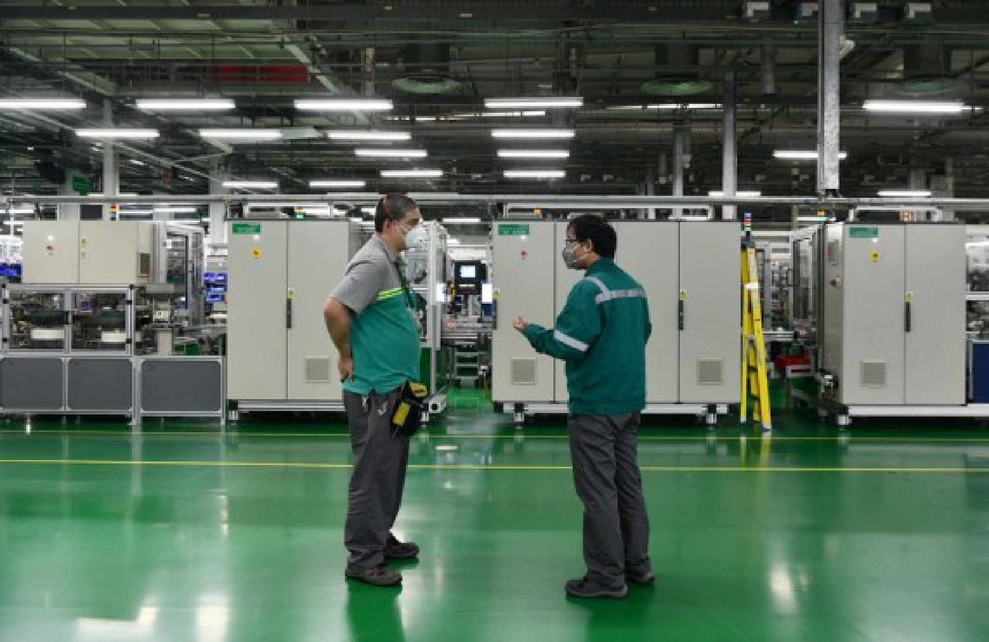 Workers communicate at the workshop of Schneider Electric Low Voltage (Tianjin) Co., Ltd. in Tianjin, north China, Feb. 25, 2020. (Xinhua/Li Ran)