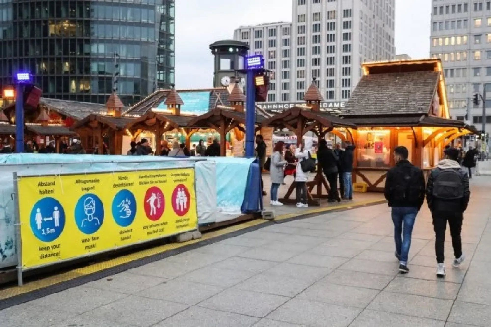 People walk past a sign to notify visitors of COVID-19 measures at a market in Berlin, Germany, on Nov. 15, 2021. (Xinhua/Shan Yuqi)