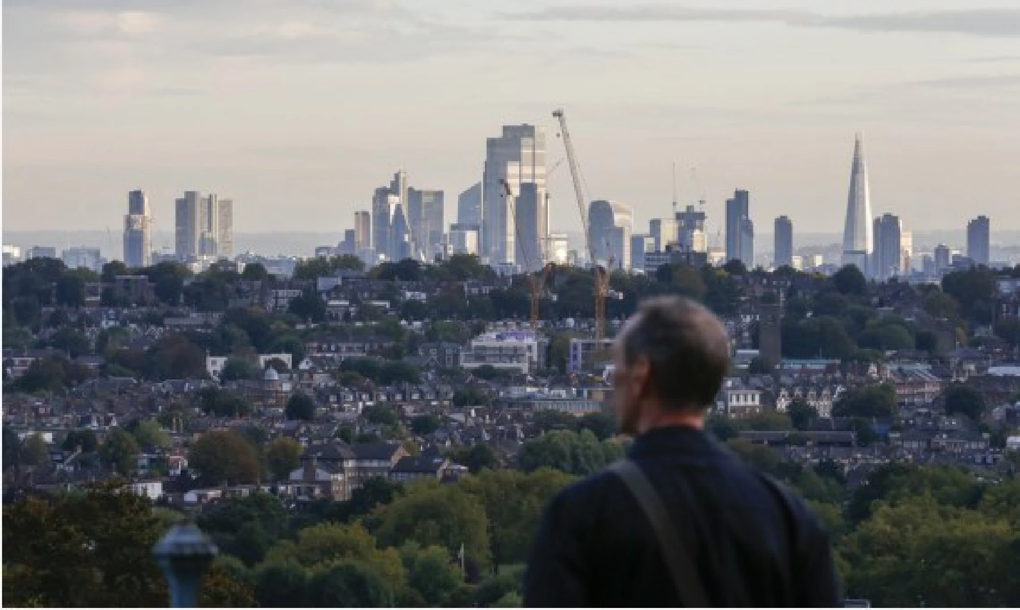 A man looks over the city from a highland in London, Britain, Oct. 17, 2021. (Xinhua/Han Yan)