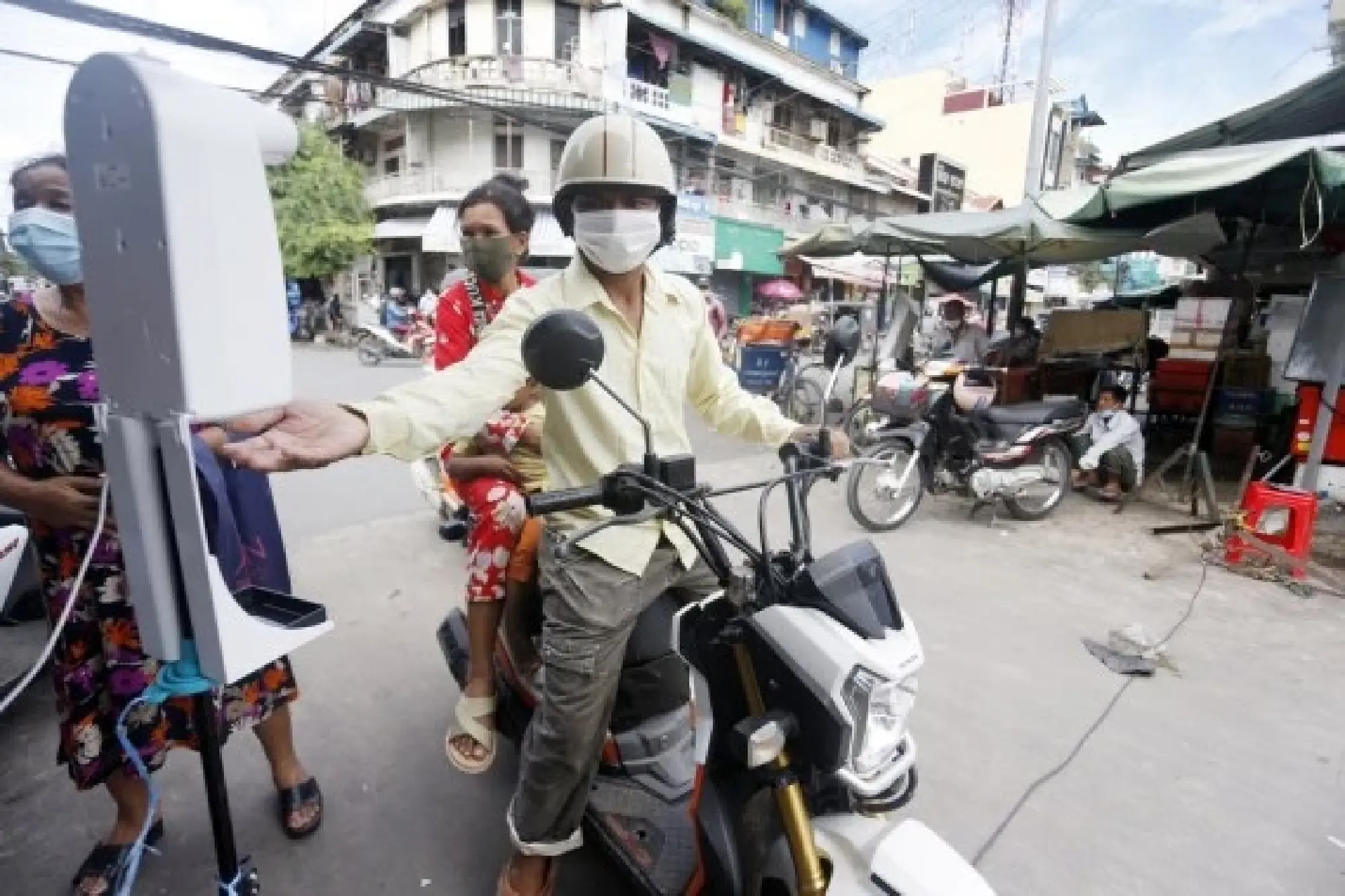 A man sanitizes his hands at a market's entrance in Phnom Penh, Cambodia on Oct. 11, 2021. (Photo by Phearum/Xinhua)