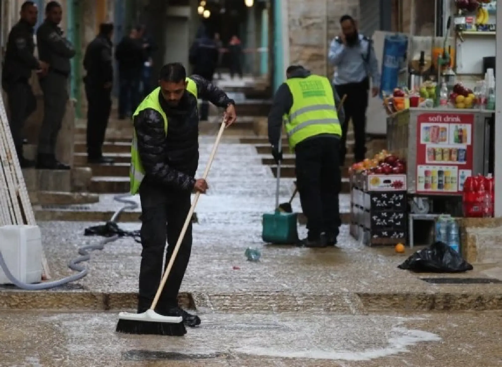 People clean a pavement following a shooting incident in Jerusalem's Old City on Nov. 21, 2021. (Photo by Muammar Awad/Xinhua)