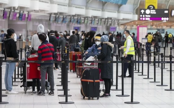Travelers wearing face masks line up to check in at Toronto Pearson International Airport in Mississauga, Ontario, Canada, on Oct. 30, 2021. (Photo by Zou Zheng/Xinhua)