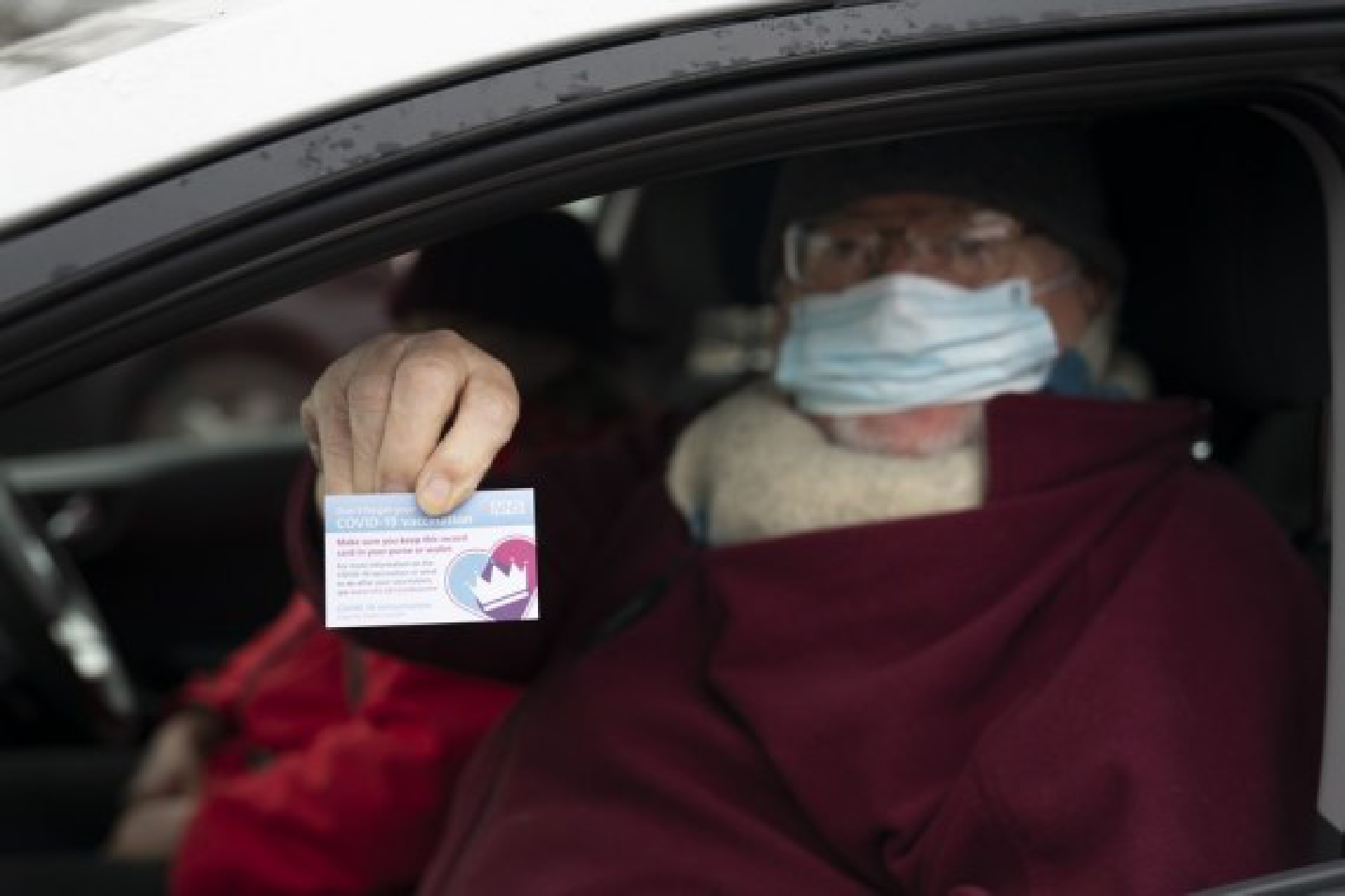 A man holds a vaccination record card after receiving the second dose of the Pfizer/BioNTech COVID-19 vaccine at Hyde Leisure Centre in Greater Manchester, Britain, on Jan. 7, 2021. (Xinhua/Jon Super)