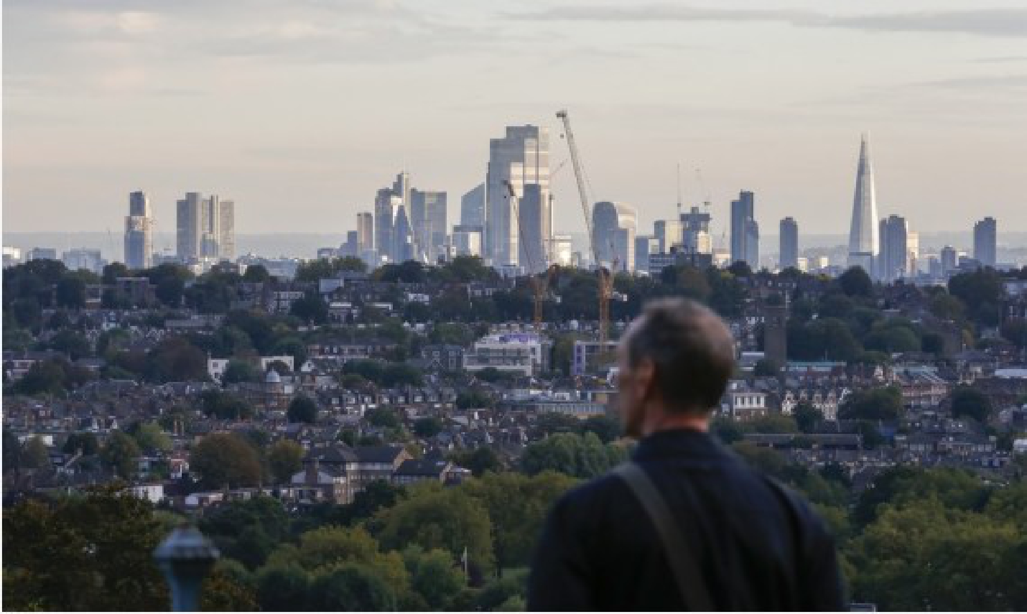 A man looks over the city from a highland in London, Britain, Oct. 17, 2021. (Xinhua/Han Yan)