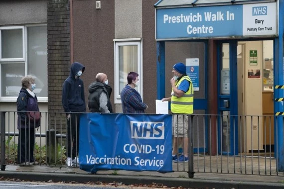 People queue up outside a vaccination center in Manchester, Britain, Nov. 10, 2021.  (Xinhua/Jon Super)