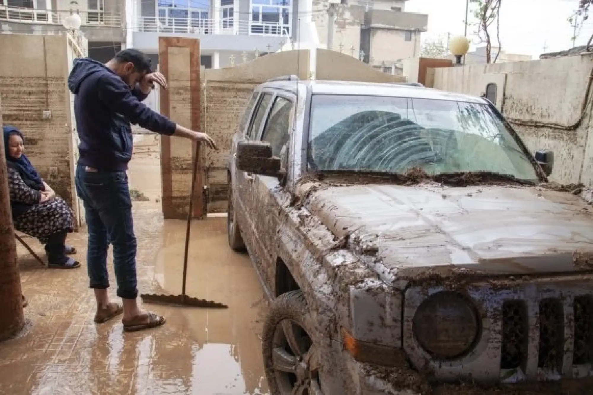 People are seen in an area hit by flash floods in Erbil, northern Iraq, on Dec. 17, 2021. (Photo by Dalshad Al-Daloo/Xinhua)