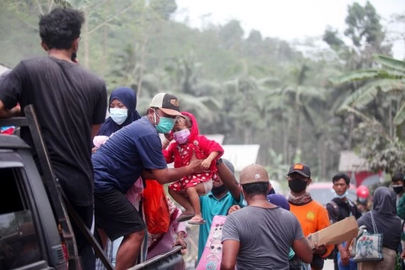 People leave for temporary shelters after Mount Semeru eruption in Lumajang, East Java, Indonesia, Dec. 5, 2021. (Photo by Kurniawan/Xinhua)