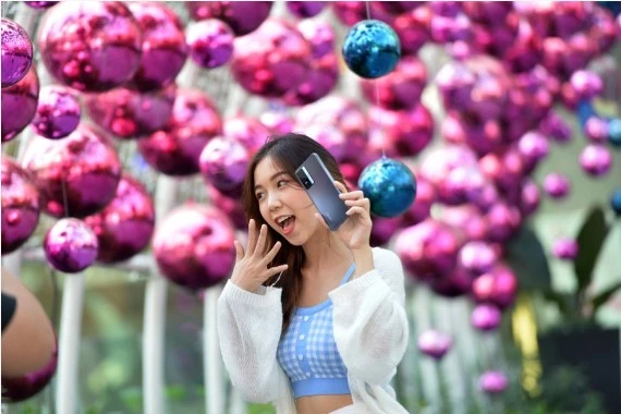 A woman is seen in front of Christmas decorations at a shopping mall in Bangkok, Thailand, on Dec. 20, 2021. (Xinhua/Rachen Sageamsak)