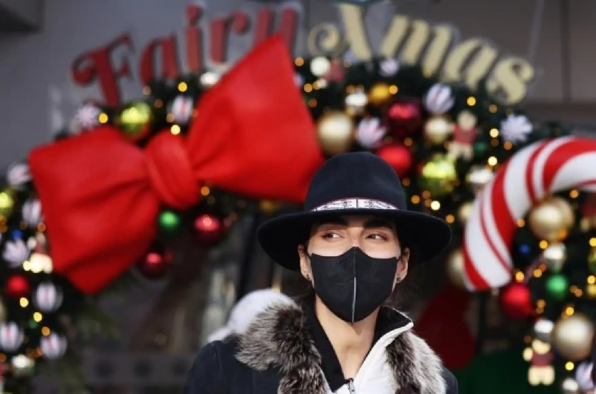 A woman wearing a face mask walks on the Champs Elysees Avenue in Paris, France, Dec. 23, 2021. (Xinhua/Gao Jing)