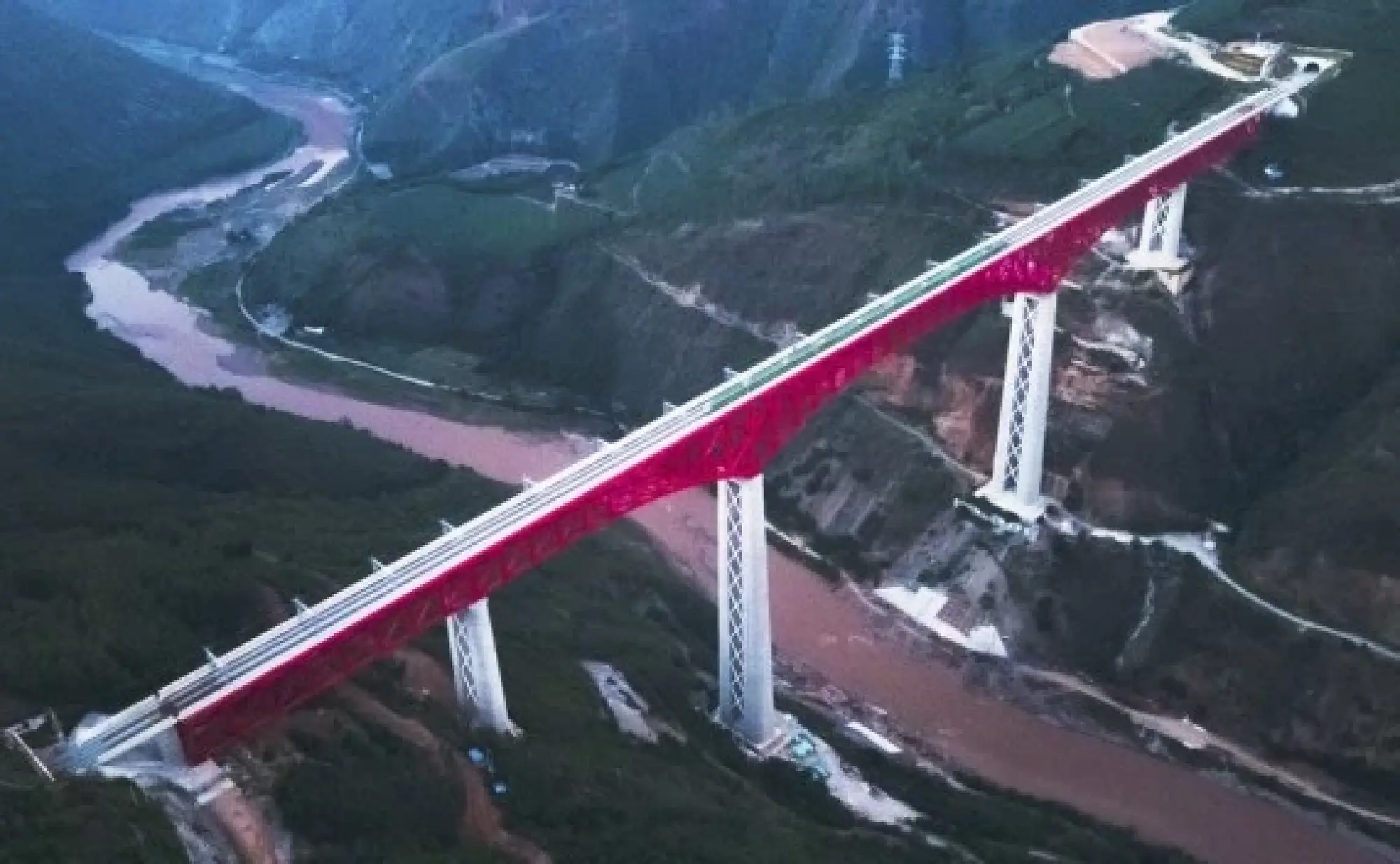 Aerial photo shows an electric multiple unit (EMU) train of the China-Laos Railway crossing a major bridge over the Yuanjiang River in southwest China's Yunnan Province, Dec. 3, 2021. The China-Laos Railway started operation on Friday. (Xinhua/Wang Guansen)