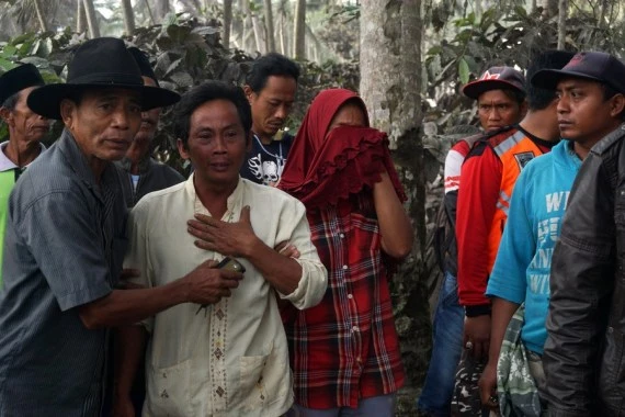 People cry in a residential area covered with volcanic ashes after Mount Semeru eruption in Lumajang, East Java, Indonesia, Dec. 5, 2021. (Photo by Kurniawan/Xinhua)