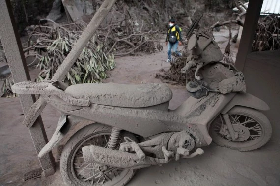 A motorbike is covered with volcanic ashes after Mount Semeru eruption at Sumberwuluh village in Lumajang, East Java, Indonesia, Dec. 5, 2021. (Photo by Bayu Novanta/Xinhua)