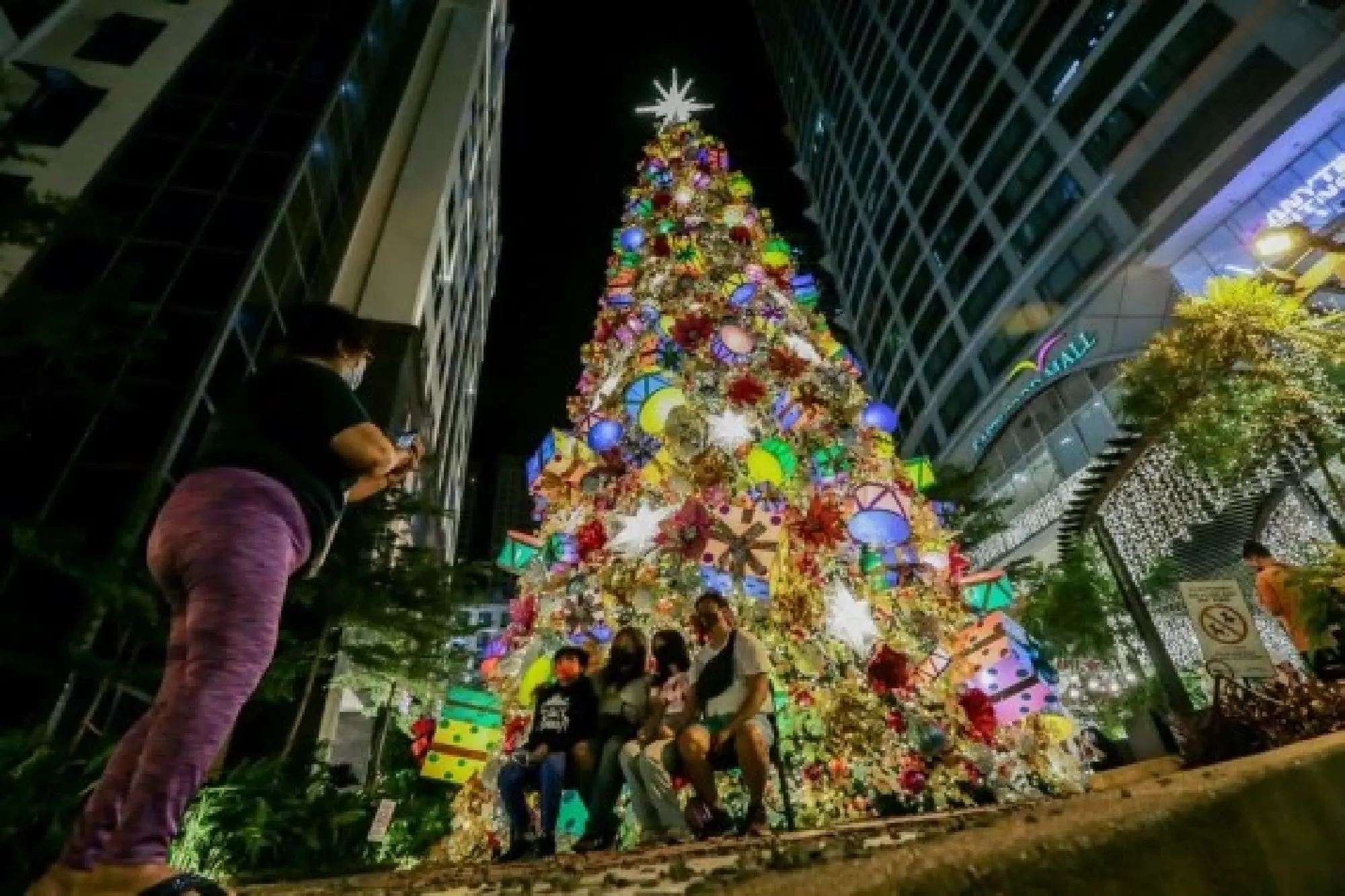 People take photos in front of a giant Christmas tree during the launch of a Christmas-themed display at a mall in Quezon City, the Philippines, on Nov. 4, 2021. (Xinhua/Rouelle Umali)