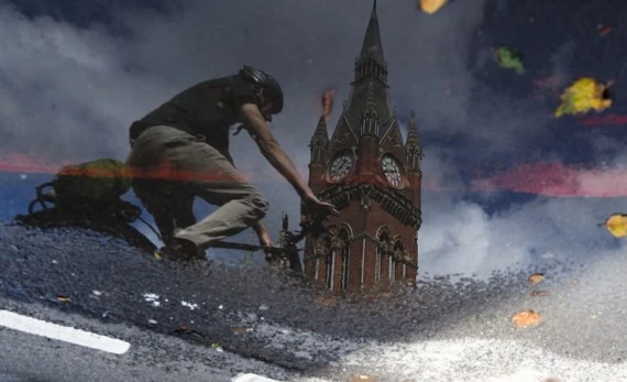  Photo rotated 180 degrees shows a cyclist riding outside St. Pancras International Station in London, Britain, July 29, 2021. (Xinhua/Han Yan)