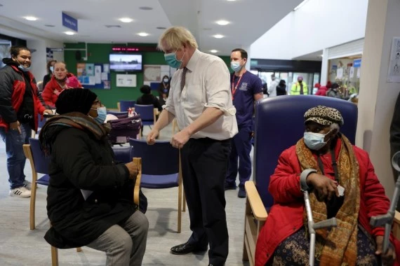 British Prime Minister Boris Johnson meets citizens having their booster shots at a COVID-19 vaccination site at Lordship Lane Primary Care Center in London, Britain, Nov. 30, 2021. (Andrew Parsons/No 10 Downing Street/Handout via Xinhua)