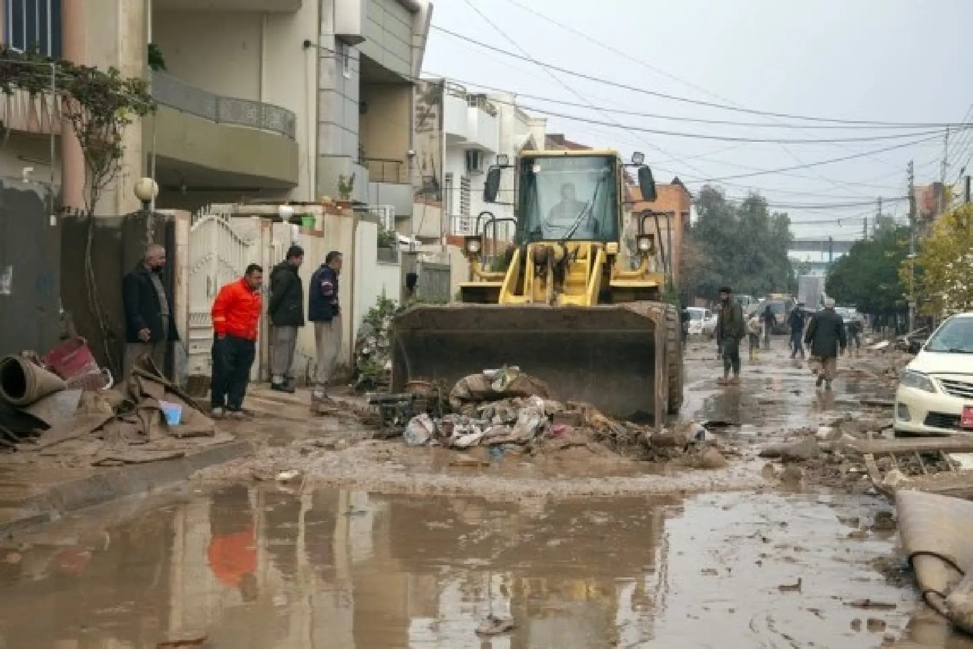 A bulldozer clears debris on a street after flash floods in Erbil, northern Iraq, on Dec. 17, 2021. (Photo by Dalshad Al-Daloo/Xinhua)