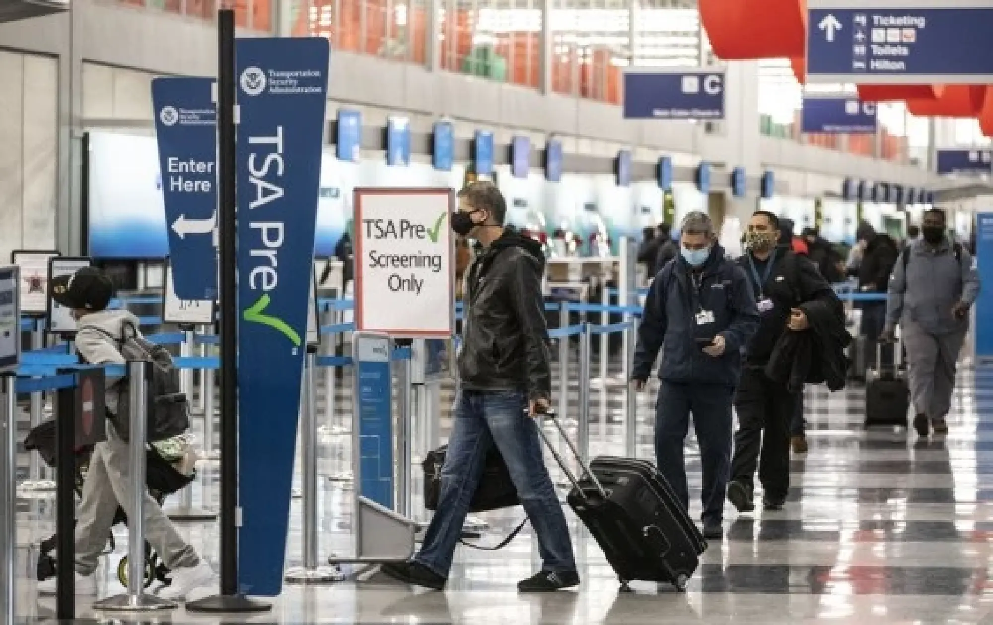 File photo taken on Nov. 25, 2020 shows travelers wearing face masks lining up for security checks at O'Hare International Airport in Chicago, the United States. (Photo by Joel Lerner/Xinhua)