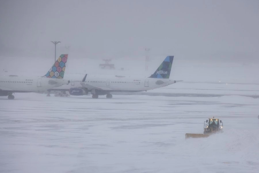 A snow plow works at John F. Kennedy International Airport in New York, the United States, Jan. 29, 2022. (Photo by Winston Zhou/Xinhua)