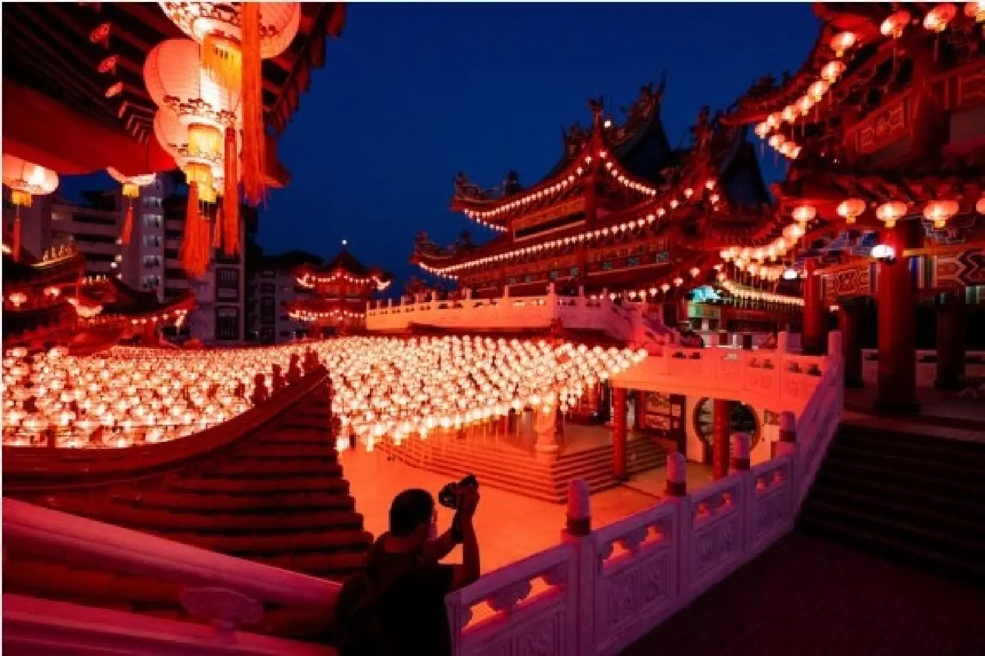 A man takes photos of the red lanterns at Thean Hou Temple in Kuala Lumpur, Malaysia, Jan. 22, 2022. (Xinhua/Zhu Wei) 