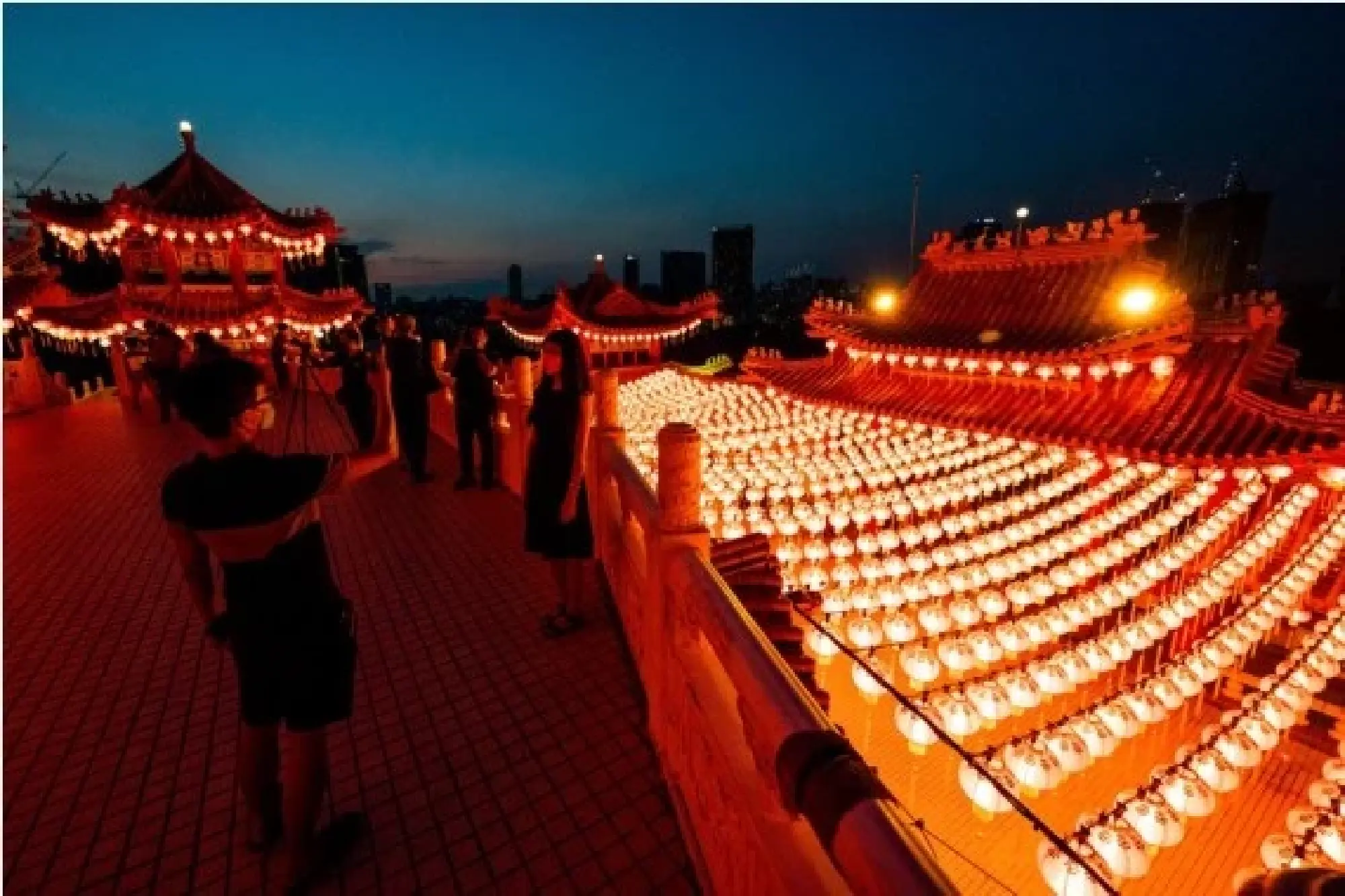 People pose for photos next to the red lanterns at Thean Hou Temple in Kuala Lumpur, Malaysia, Jan. 22, 2022. (Xinhua/Zhu Wei) 