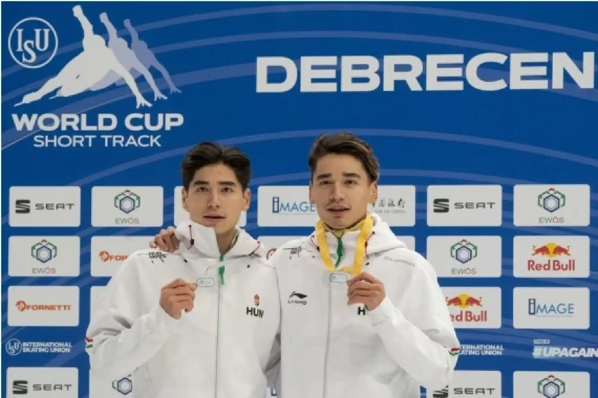 Gold medalist Liu Shaolin (R) of Hungary and his brother silver medalist Liu Shaoang of Hungary celebrate during the awarding ceremony after the men's 500m final at the ISU World Cup Short Track Speed Skating series in Debrecen, Hungary, Nov. 20, 2021. (Photo by Attila Volgyi/Xinhua)