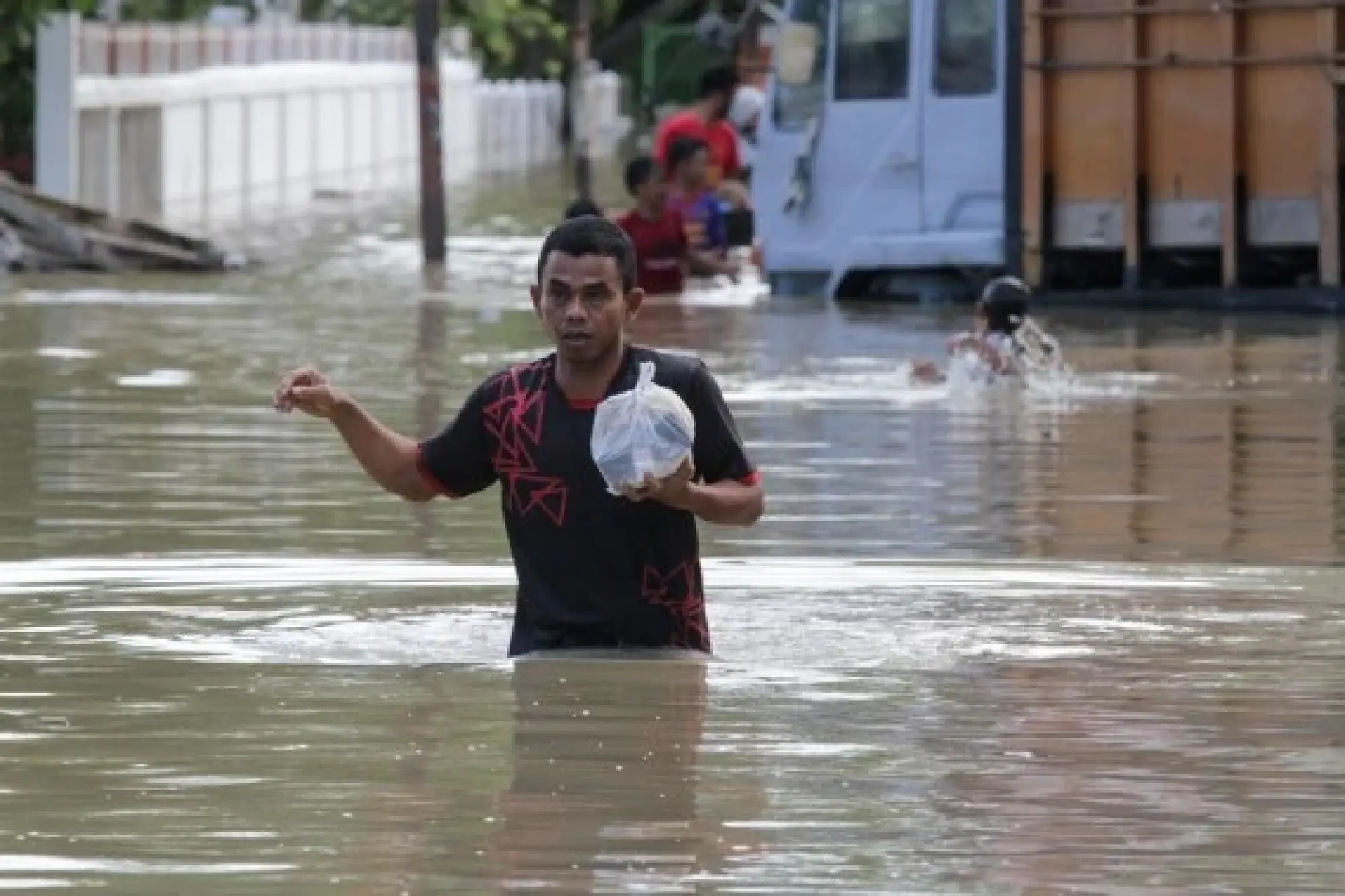 A man wades through floodwater in Lhoksukon of Aceh Province, Indonesia, Jan. 4, 2022. (Photo by Fachrul Reza/Xinhua)