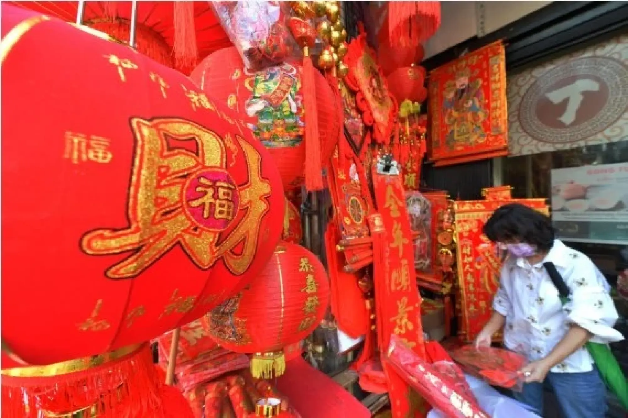 A customer picks Spring Festival decorations at a store in the China Town of Bangkok, Thailand, on Jan. 25, 2022. (Xinhua/Rachen Sageamsak)