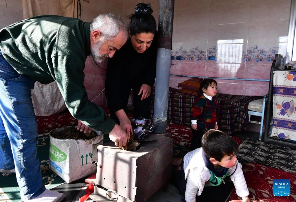 Al-Muthana Hasan al-Shoufi, 53, and his family use cow dung as heating fuel in Sweida, Syria, on Jan. 23, 2022. As heating fuel has become out of reach for many Syrians because of the U.S. economic sanctions and its control over key oil fields in the country, farmers in the southern province of Sweida now resort to cow dung as an alternative to survive the harsh winter.(Photo by Ammar Safarjalani/Xinhua)