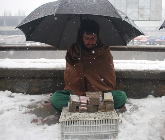An Afghan currency exchange dealer waits for customers in Kabul, Afghanistan, Feb. 6, 2022. (Photo by Saifurahman Safi/Xinhua)